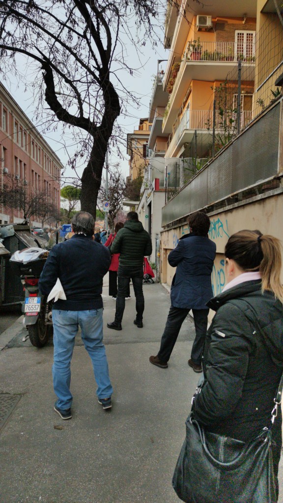 Kuvassa ihmisiä jonossa ruokakauppaan